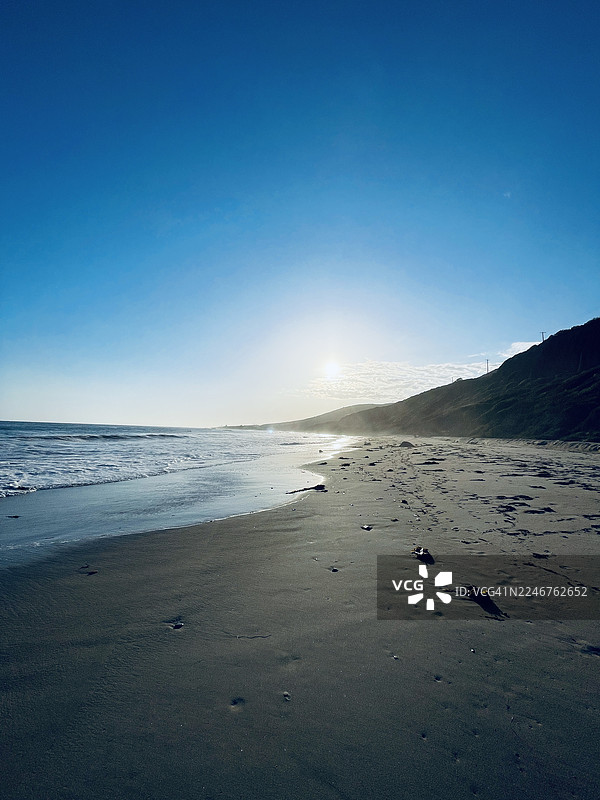 晴朗蓝天下带有阳光炫光的海岸风景图片素材