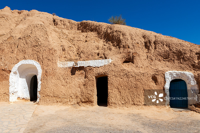 突尼斯马特马塔，山上雕刻的古老穴居人住所，天空晴朗蔚蓝图片素材