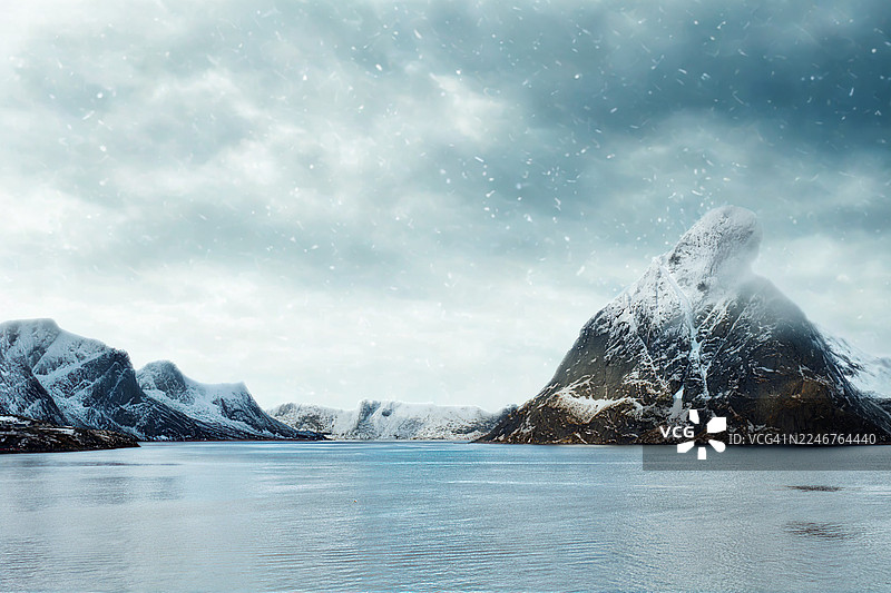 冬季降雪中覆盖着雪的山脉和峡湾的风景图片素材