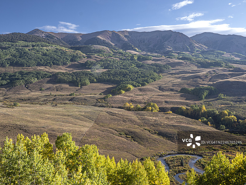秋季山景，蜿蜒河流穿过，蓝天下的克雷斯特德比特，美国图片素材