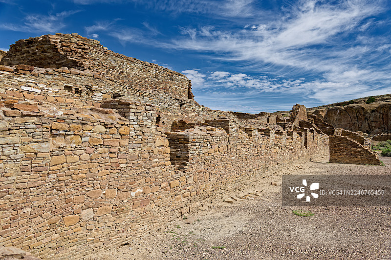 美国法明顿查科文化国家历史公园，古老的普韦布洛博尼托遗址在动态的蓝色天空和缕缕白云下图片素材