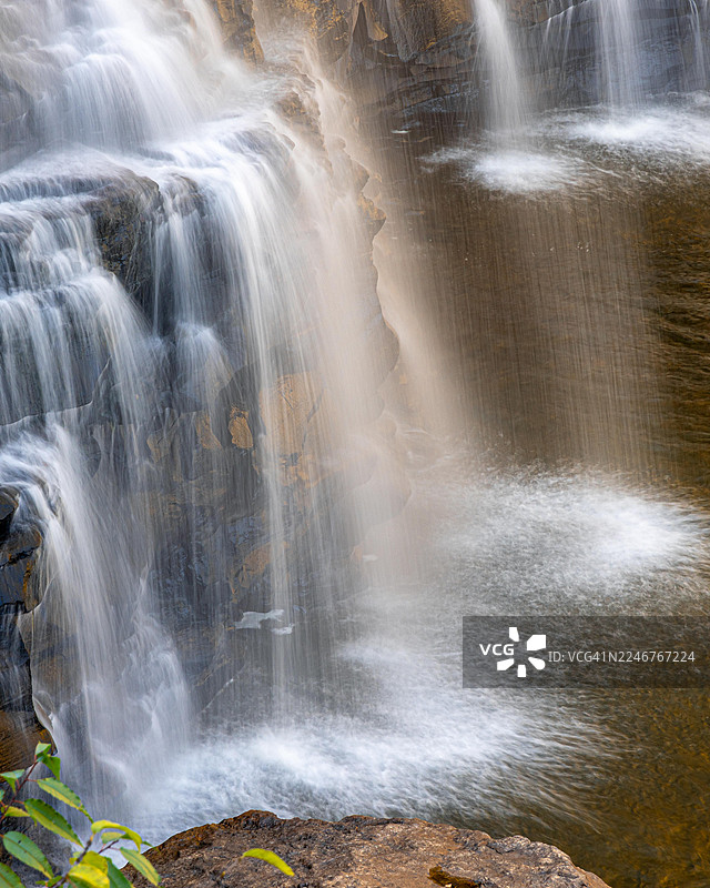 一张充满力量的瀑布近景，水流倾泻在崎岖的岩石上，激起迷蒙的水雾。地点：美国，里弗顿，罗伊盖普路。图片素材