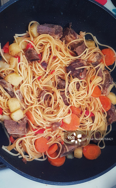 烹饪锅中面条、肉类和蔬菜的俯视视图图片素材