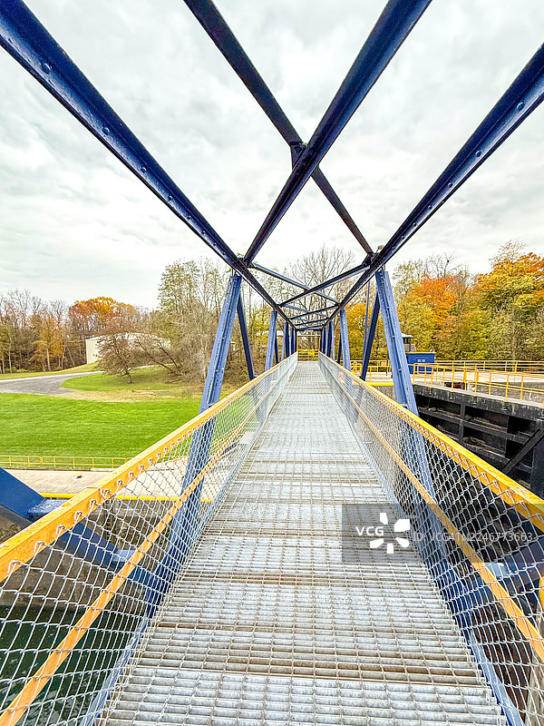 纽约州塞内卡福尔斯，卡尤加-塞内卡运河船闸上的钢制人行桥图片素材