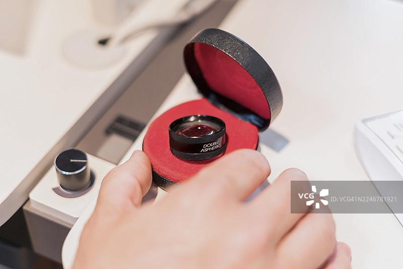 手持双非球面镜片进行眼科检查图片素材