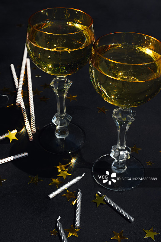 一副眼镜、香槟、派对帽和彩带组成的背景。节日背景。生日。派对后的场景。喧闹的欢乐。图片素材