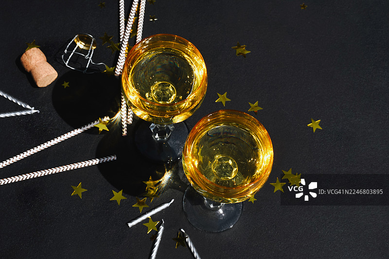 眼镜、香槟、派对帽和彩纸组成的背景。节日背景。生日。派对的残局。喧闹的乐趣。图片素材