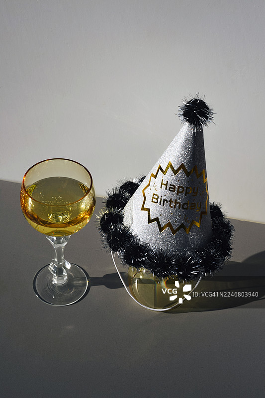 眼镜、香槟、派对帽和彩带的背景。节日背景。生日。派对后的场景。热闹的乐趣。图片素材