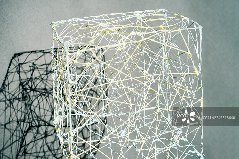 由交织的细线构成的抽象几何结构，形成透明的网状形状。图片素材