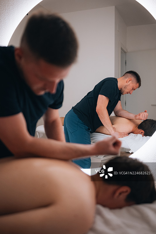 理疗师为男患者提供治疗性按摩图片素材