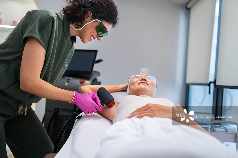 漂亮的女性医生正在进行激光脱毛图片素材