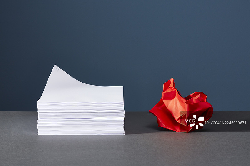 揉成一团的纸球放在一叠纸旁边图片素材