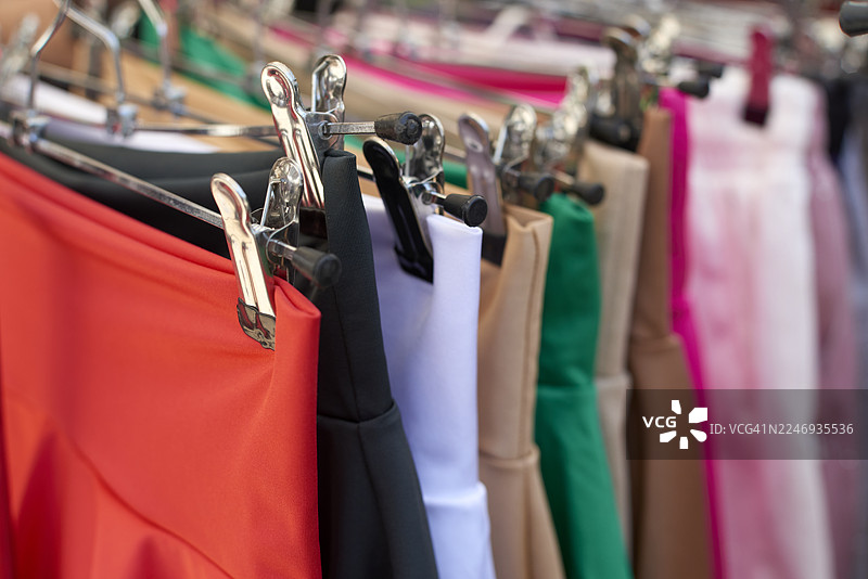 色彩鲜艳的裙子挂在零售服装架上图片素材