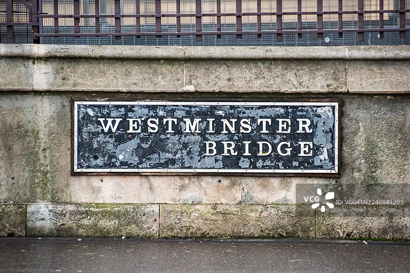 西敏桥风化磨损的名称铭牌镶嵌在石砌栏杆上图片素材