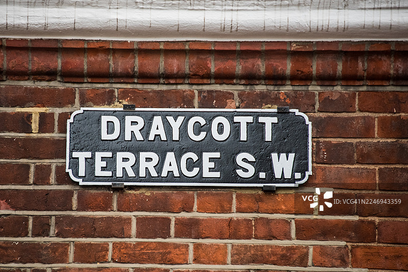 切尔西伦敦深色砖墙上的德雷科特露台街牌图片素材