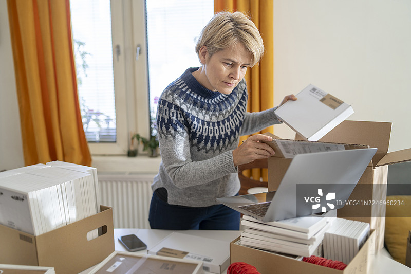 一位女士正在为她的网店打包订单图片素材