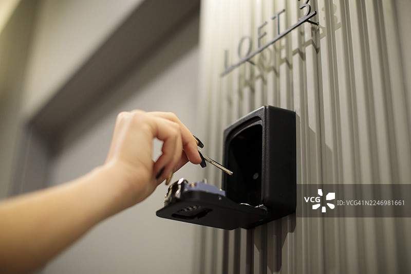女士的手从嵌入式保险箱中取出钥匙图片素材