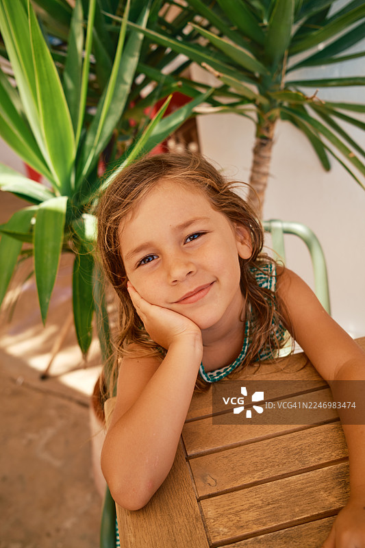 微笑的年轻女孩在户外用手托着下巴图片素材