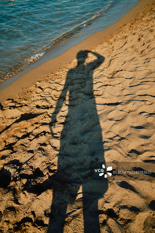 海边沙滩上，一个人的影子在搜寻地平线图片素材