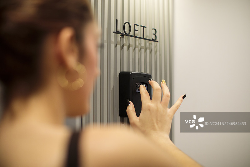 女性的手从嵌入式保险箱中取出钥匙图片素材