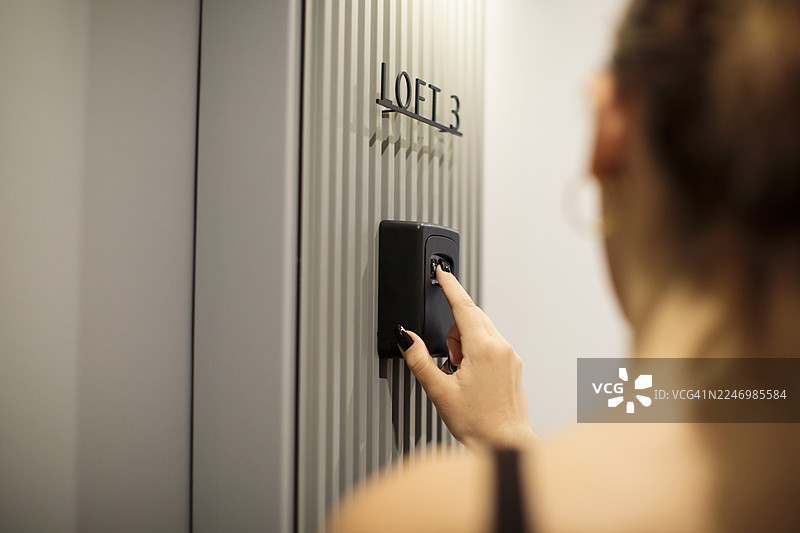 女士的手从嵌入式保险箱中取出钥匙图片素材