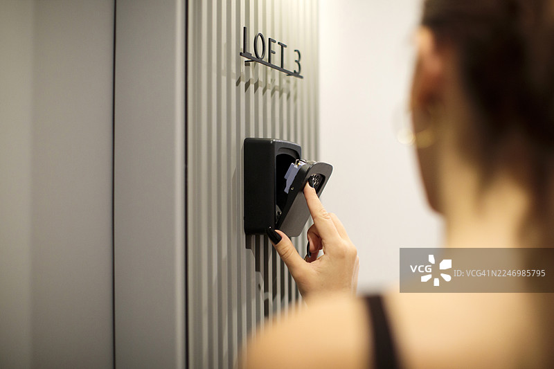 女士的手从嵌入式保险箱中取出钥匙图片素材