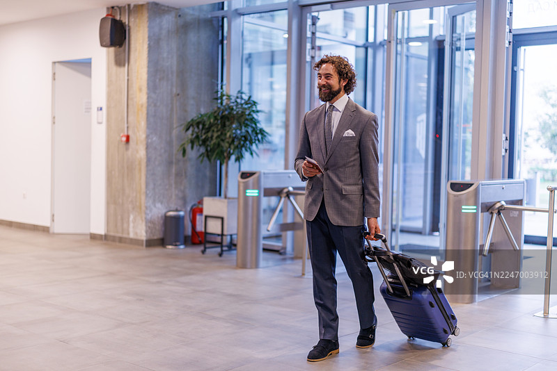 商务人士携行李通过现代机场闸机图片素材