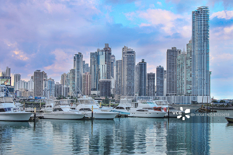 巴拿马城高层建筑天际线在蓝色时刻，海湾中有游艇图片素材