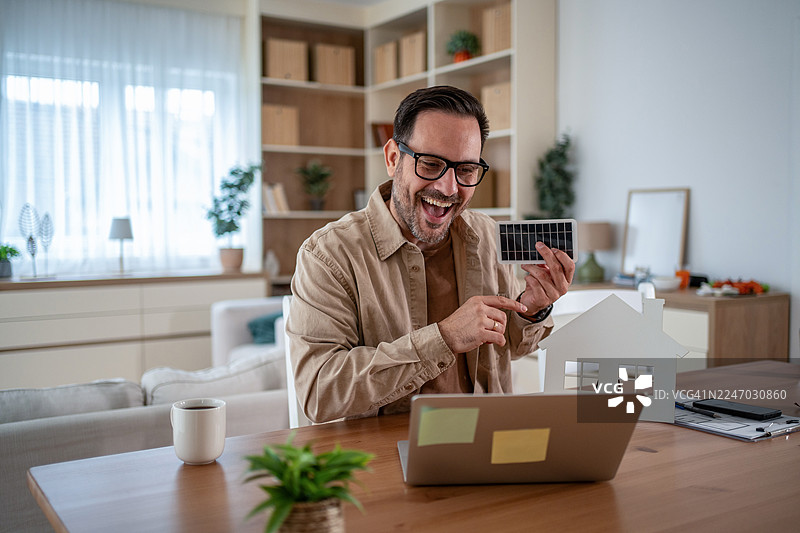 男子在家通过视频通话展示太阳能电池板图片素材