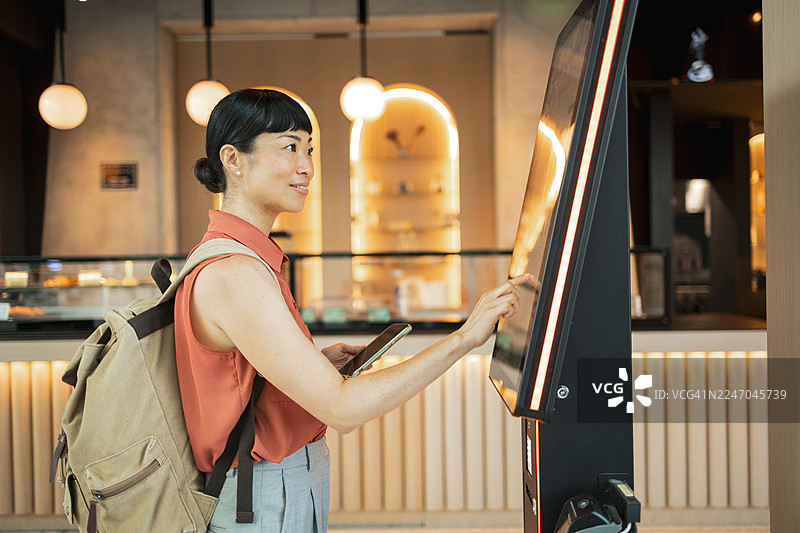 游客在咖啡馆使用自助点餐机图片素材