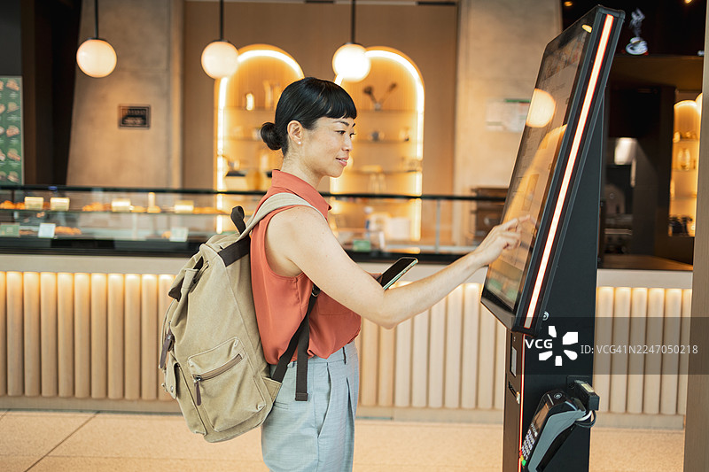 游客在餐厅使用自助点餐机点餐图片素材