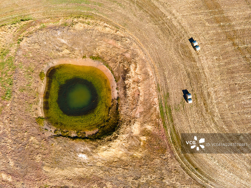 澳大利亚西部诺斯丹达拉普附近，近期收割的麦田，内有农场水坝和圆形干草包图片素材