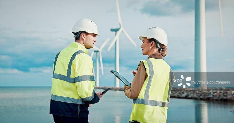 风力涡轮机，规划和环境工程师在现场使用平板电脑进行维护或维修。团队合作，风车和运营经理使用数字技术在户外进行可再生能源工作。图片素材