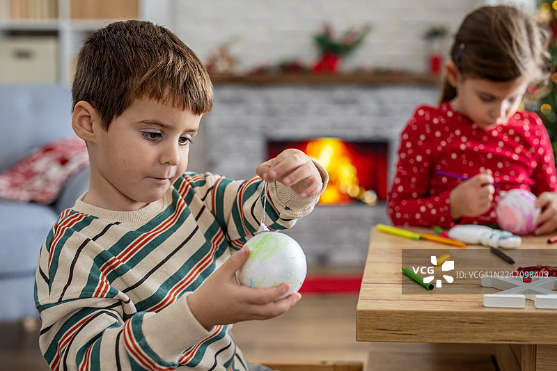 年轻艺术家们在绘制节日树装饰品图片素材
