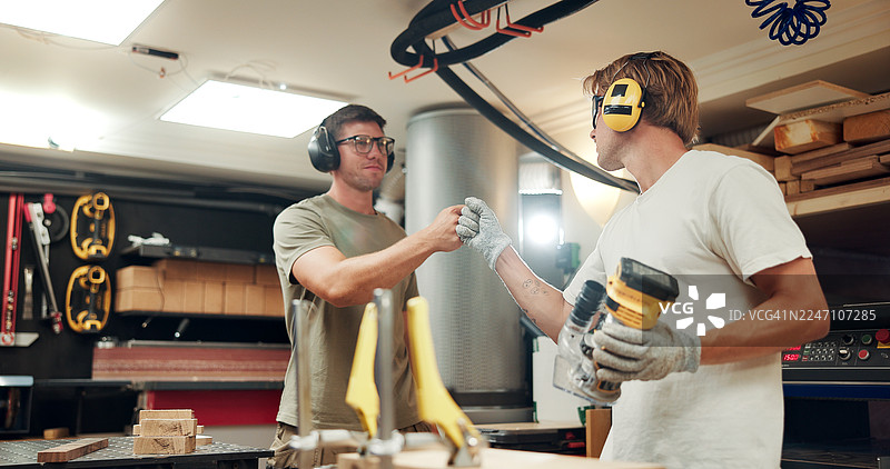 木工在车间里握拳，展示工具，进行制造、支持和木工项目。这是一个关于手工、木材和家具组装的生产、工匠和杂工项目，涉及人们在车库中的活动。图片素材
