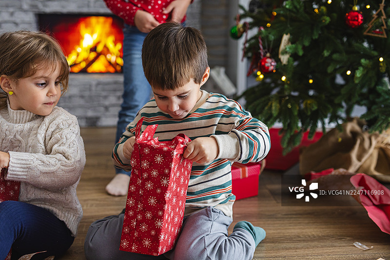 孩子们在家里拆圣诞节早晨的礼物图片素材
