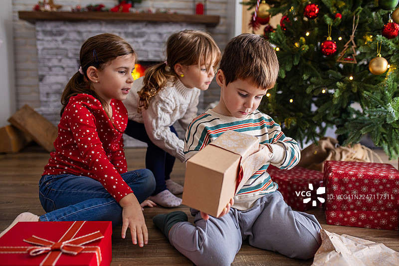 孩子们一起拆开节日的礼物图片素材