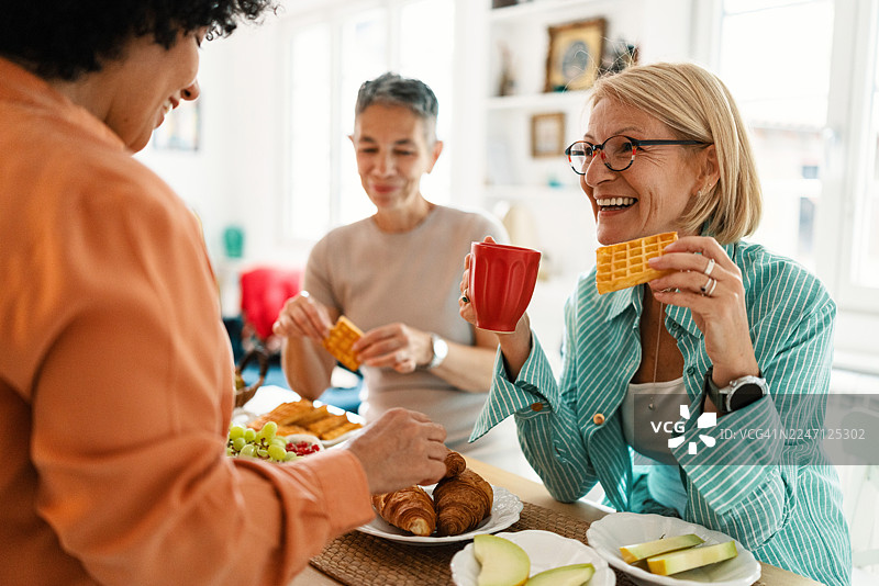 快乐的中年女性在早午餐时聊天图片素材