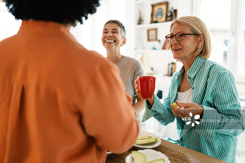 在家吃早午餐时，成熟的朋友们正在享用水果图片素材