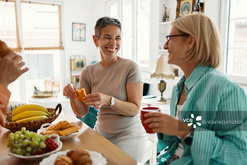 成熟的朋友在家吃早午餐时享用水果图片素材