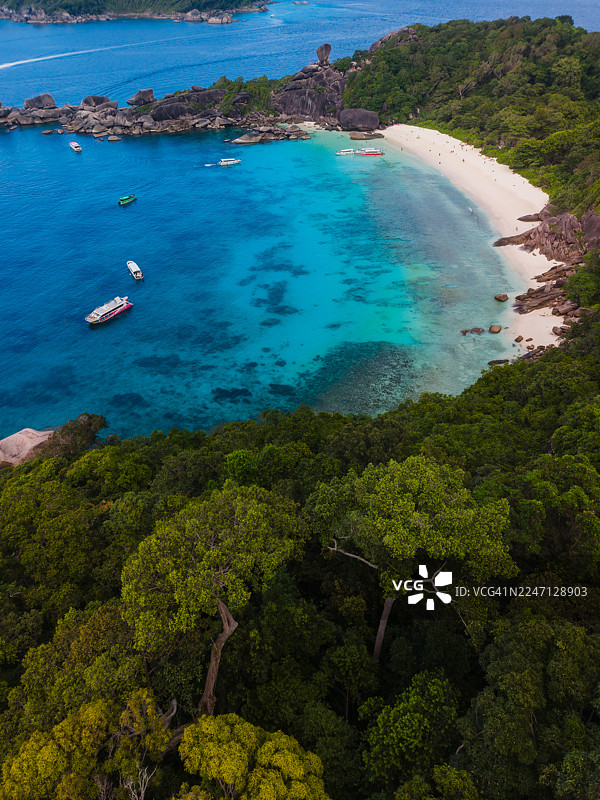 停靠着船只和拥有白色沙滩的热带岛屿海湾图片素材