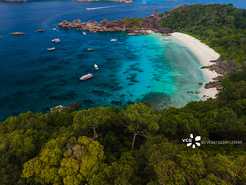 载有船只的热带岛屿海湾和白色沙滩图片素材
