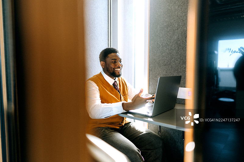 商务人士在办公室隔间使用笔记本电脑进行视频通话图片素材