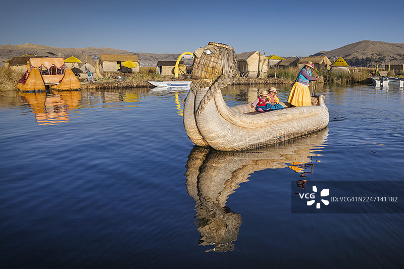 秘鲁年轻女子在的的喀喀湖乌鲁斯浮岛间航行图片素材