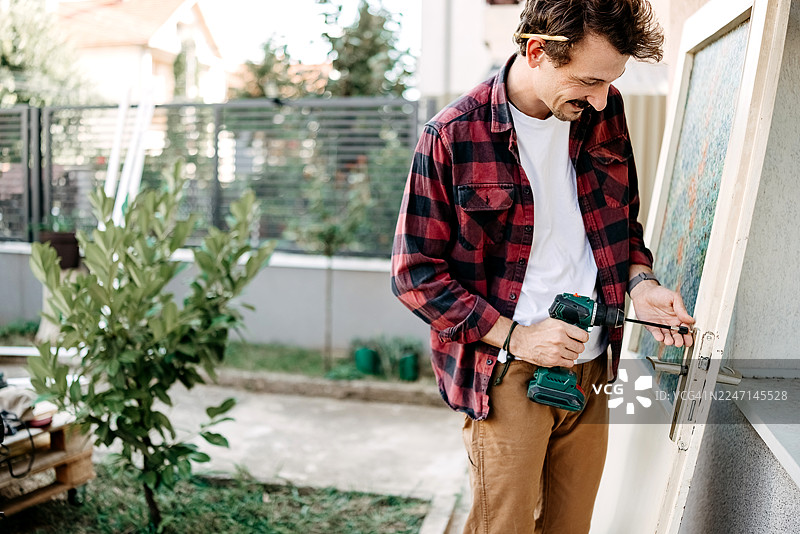 男人准备刷漆的门图片素材