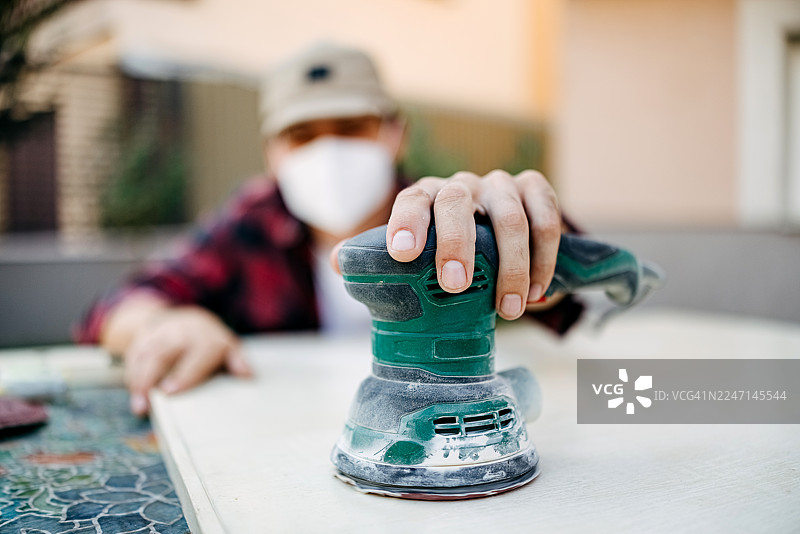 男人正在给门刷漆。图片素材