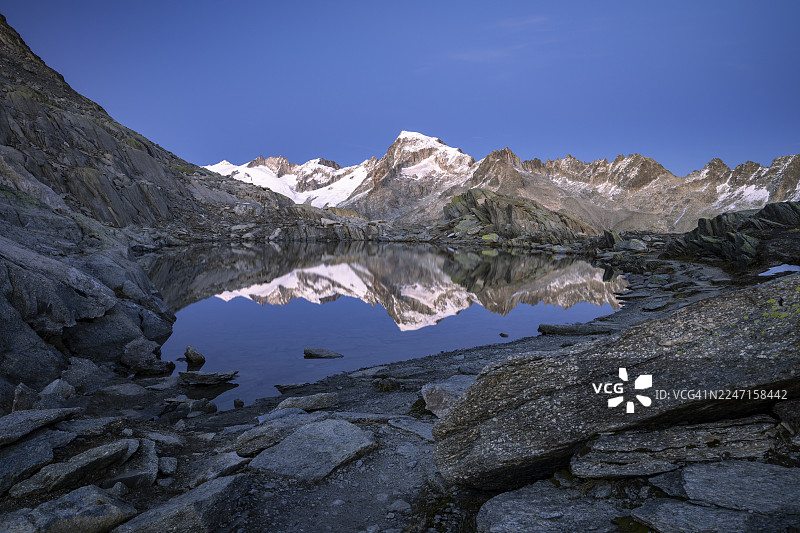 瑞士瓦莱州格雷特利湖(Grätlisee)的贝尔格湖(Bergsee)倒映着加伦斯托克山(Galenstock)。图片素材