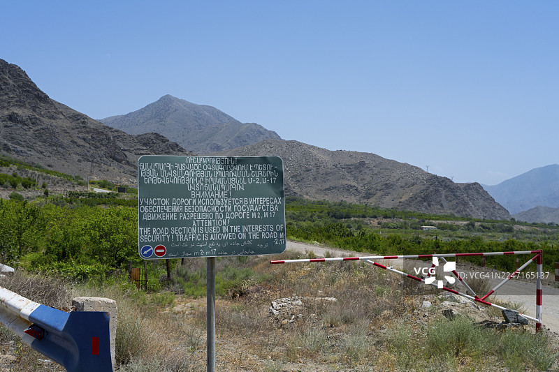 亚美尼亚亚洲,苏尼克省,M17公路边境旁,路旁立着指示牌和路障,并有安全警示。指示牌和路障立在有安全警示的山路上。图片素材