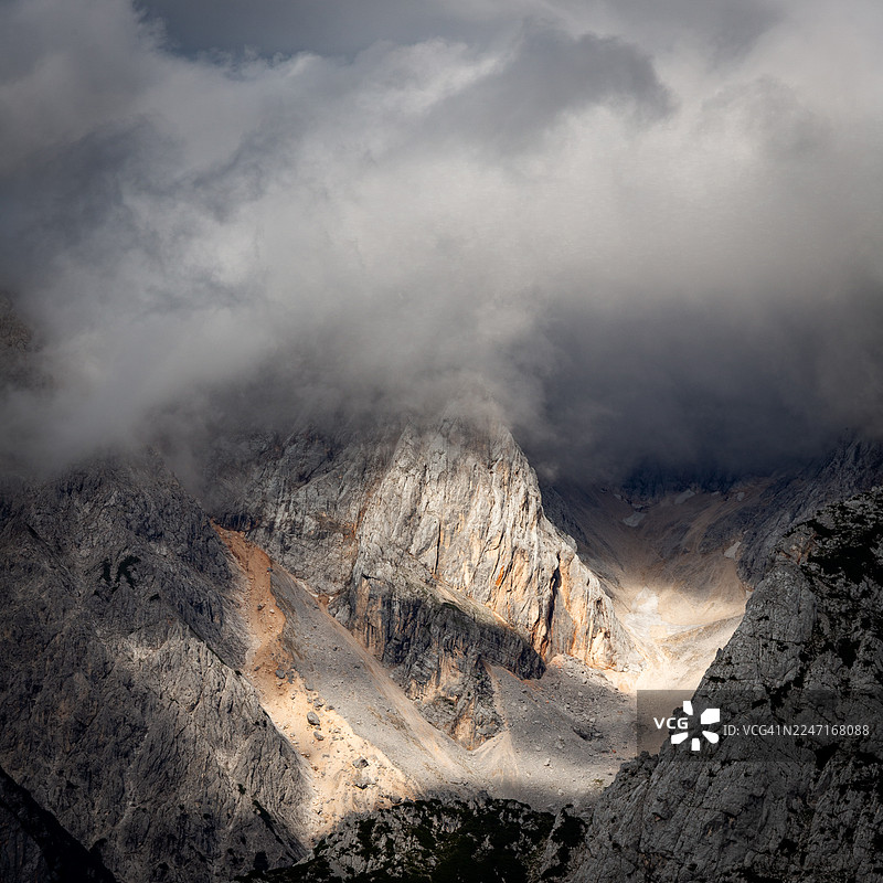 从空中俯瞰，阳光穿透云层，照亮斯洛文尼亚博韦茨的山脉，景象壮观图片素材