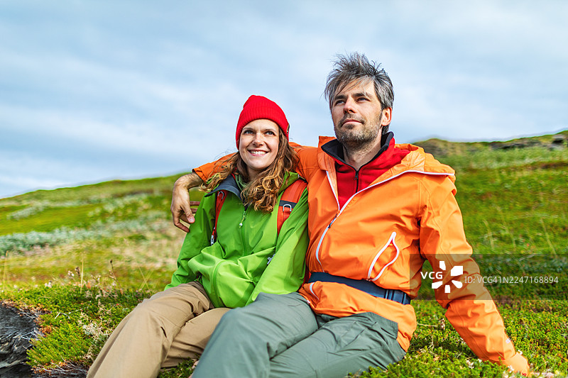 中年夫妇徒步休息，坐着欣赏风景图片素材